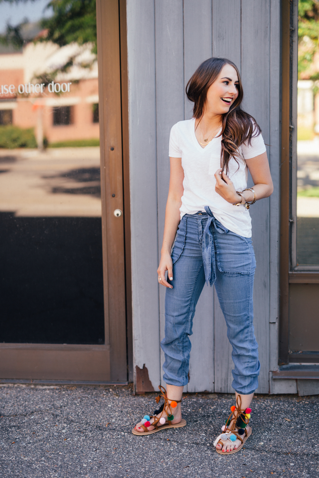 Denim Joggers and white madewell tee with pom pom shoes with long brown curled hair