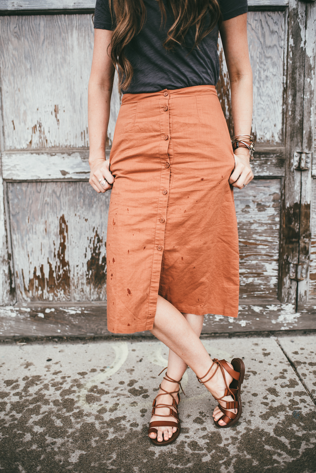 orange button up skirt paired with grey top and brown sandals