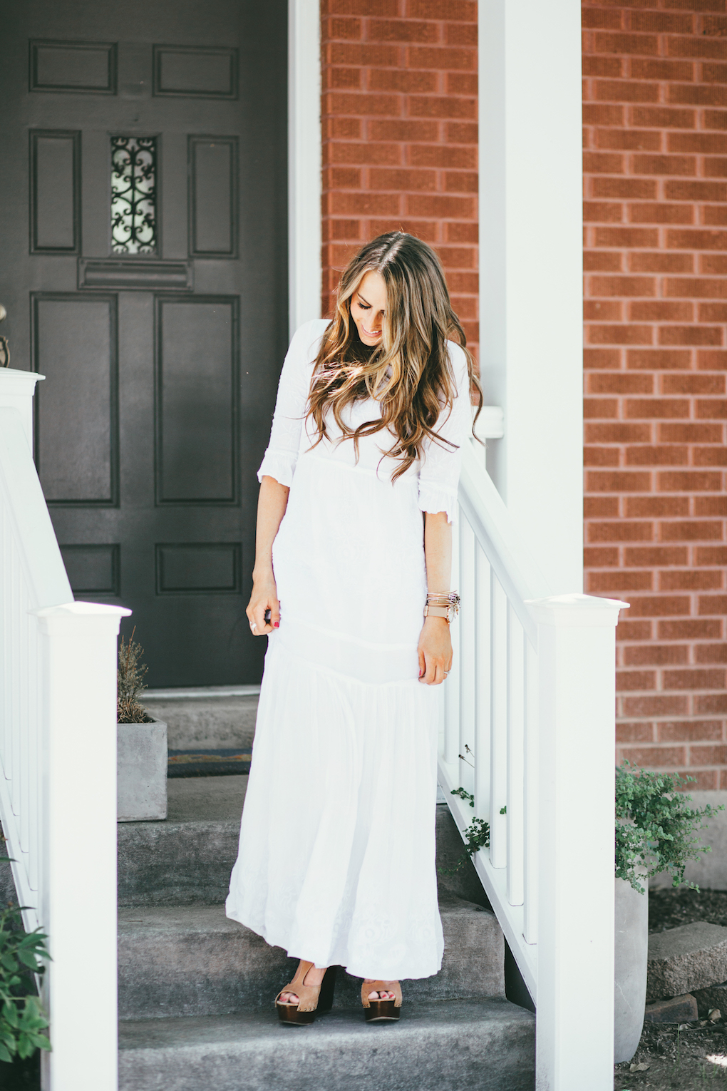 Girl in long white embroidered maxi dress with long loose caramel and brown curls