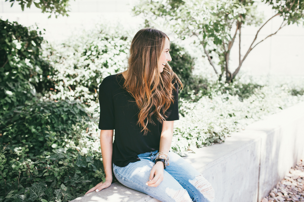 Girl in distressed denim jeans and oversized black tee shirt with loosely curled hair