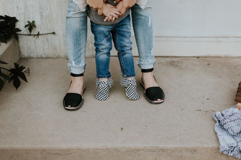 little boy in skinny distressed denim and black and white checked freshly picked moccasins with mom in distressed denim and pons shoes