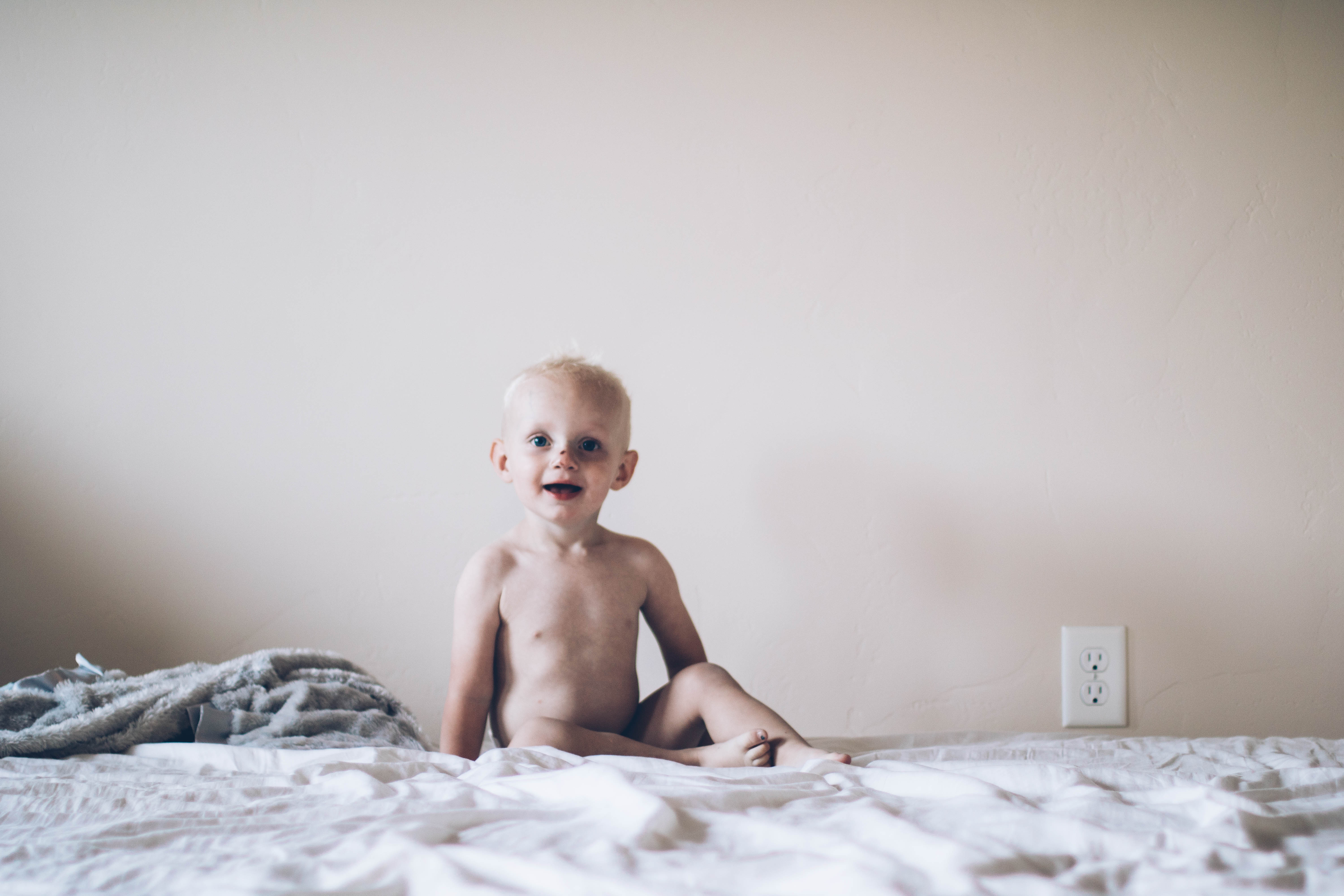 Little boy sitting on bed with Bambo Nature Diaper