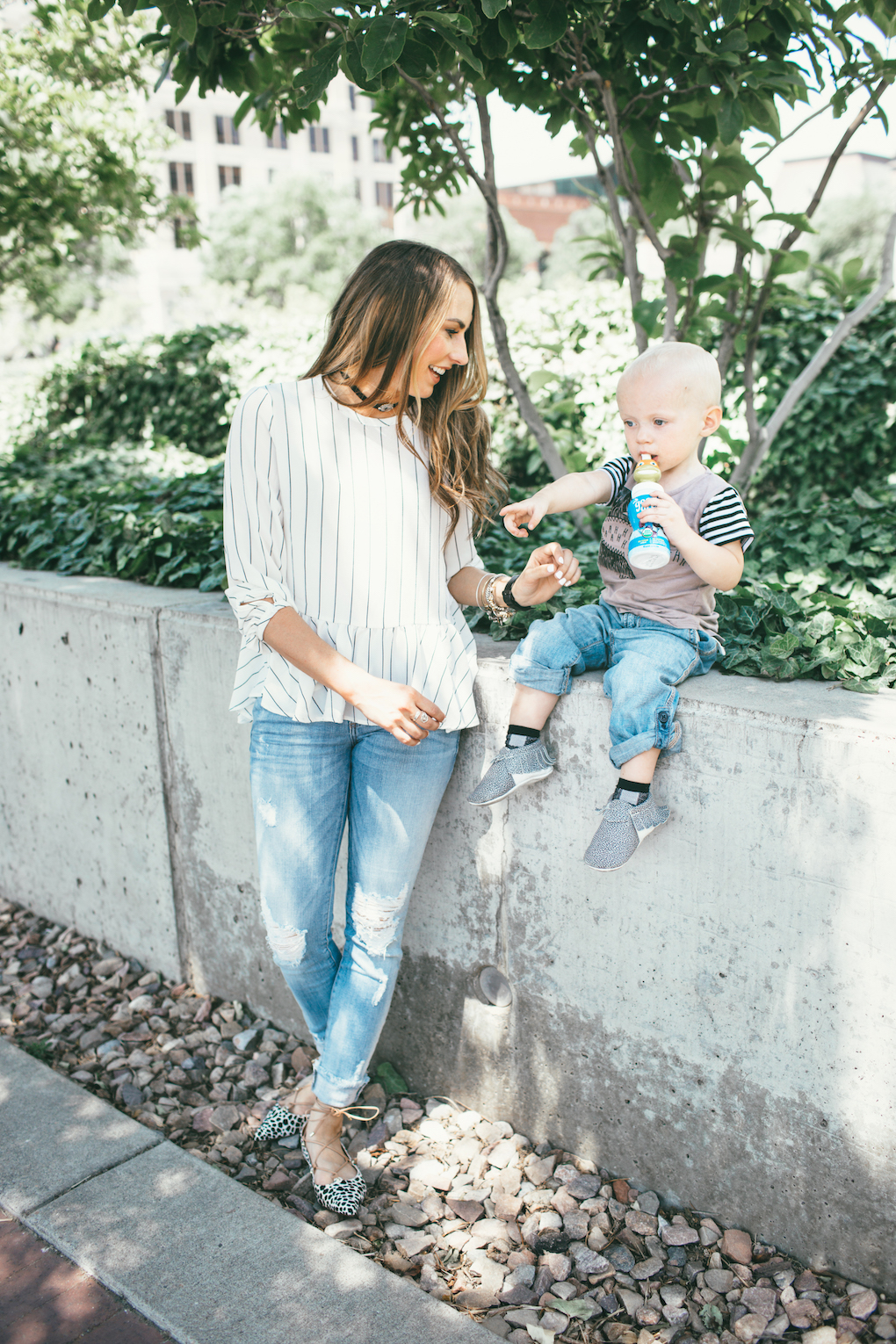 Mom in white stripe peplum black choker and distressed denim little boy wearing rags to raches tee shirt with rolled up denim and freshly picked moccs
