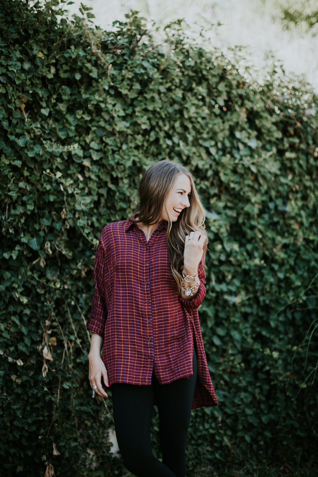 Girl laughing wearing red oversized flannel with leggings. 