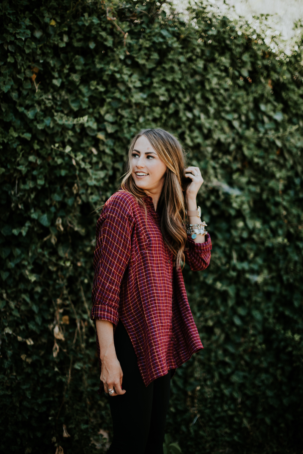girl turned side ways laughing in red oversized flannel