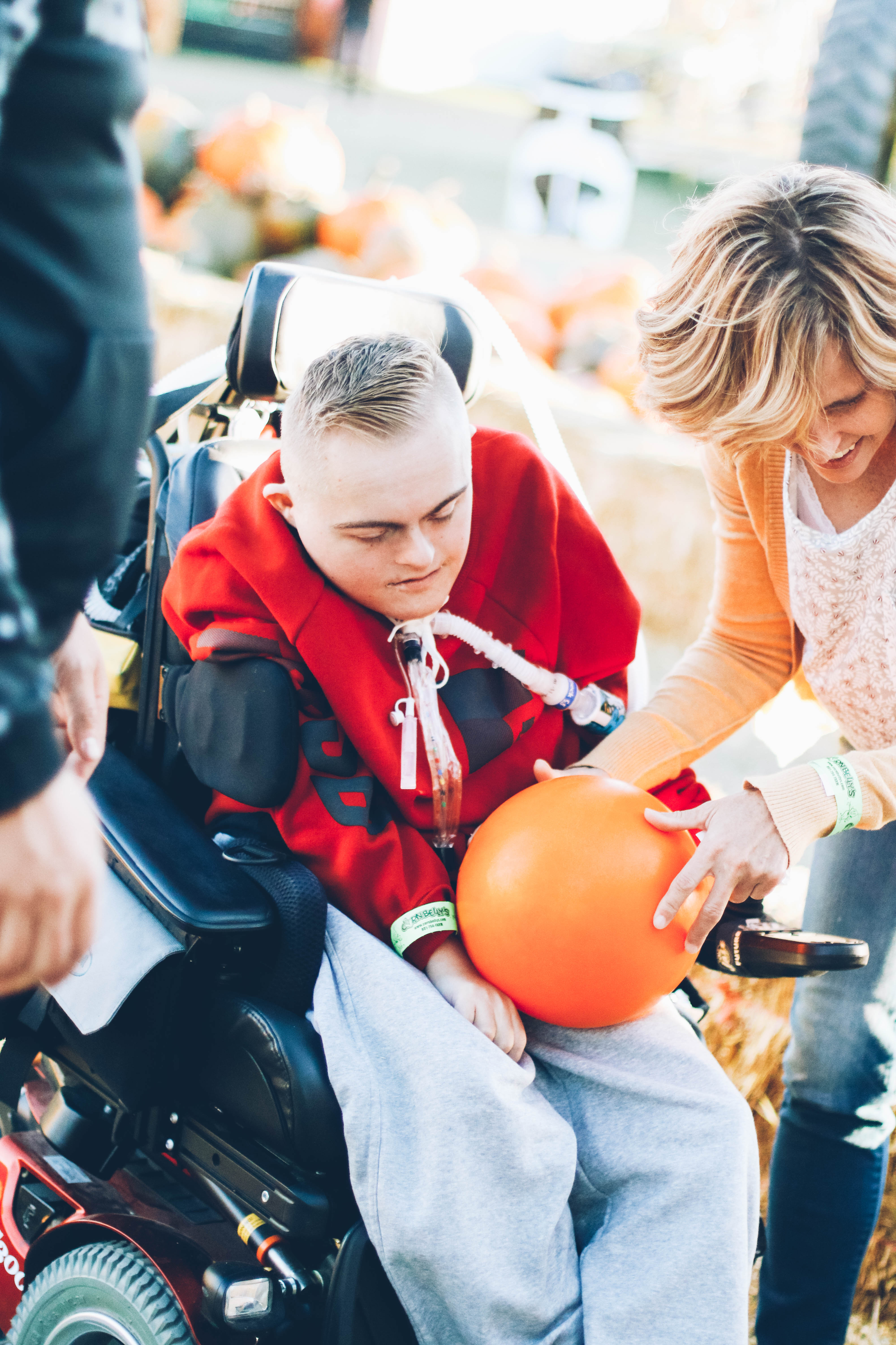 mom and special needs boy playing pumpkin bowling at corn maze