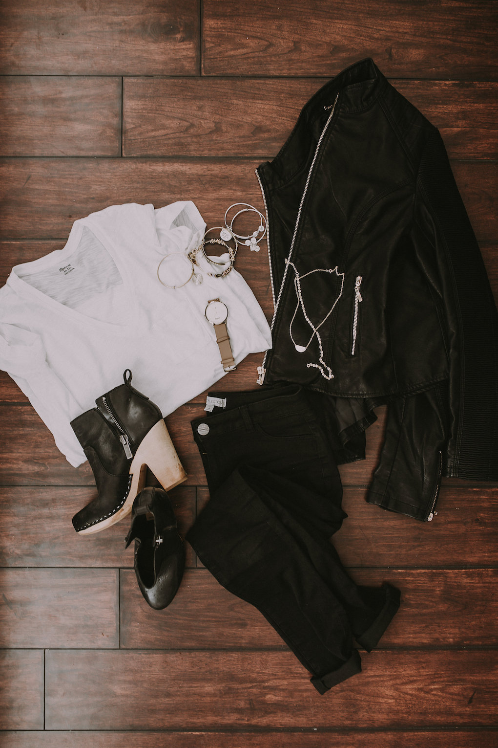 black leather jacket and basic white tee paired with black jeans with holes in the knees and blcak booties