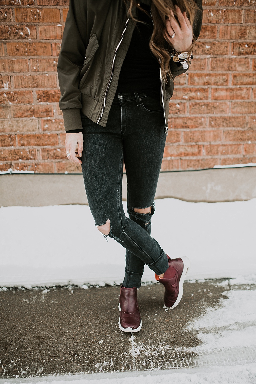 girl standing in black jeans with bomber jacket and nike boots
