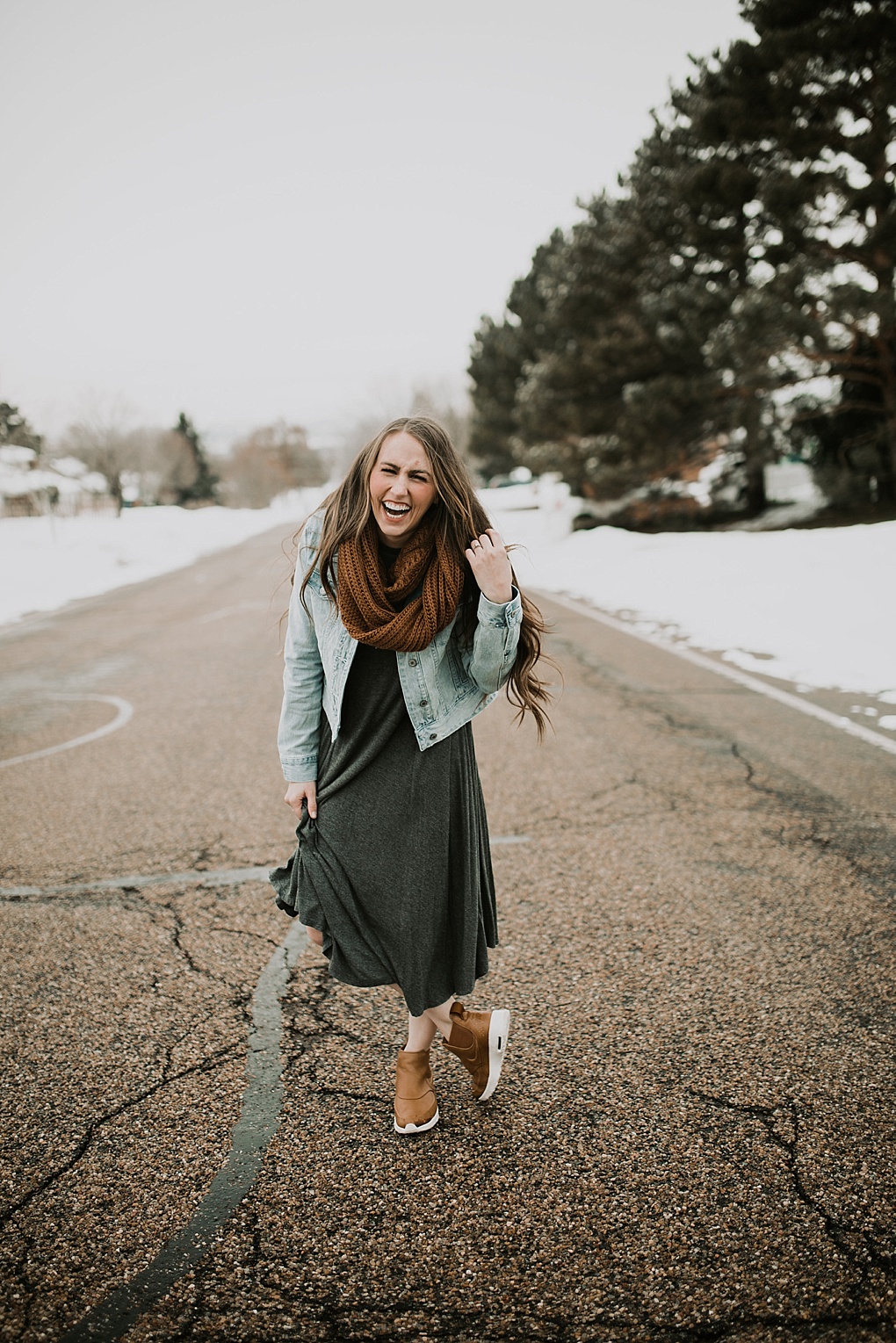 girl standing in road in oversized grey dress with denim jacket brown knit infinity scarf nike boots