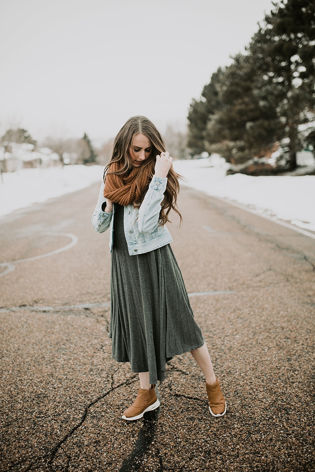 girl standing in road in oversized grey dress with denim jacket brown knit infinity scarf nike boots