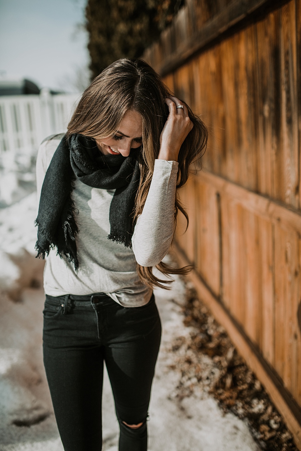 3 ways to tie blanket scarves girl standing in snow in basic tee black jeans and wearing a black blanket scarf