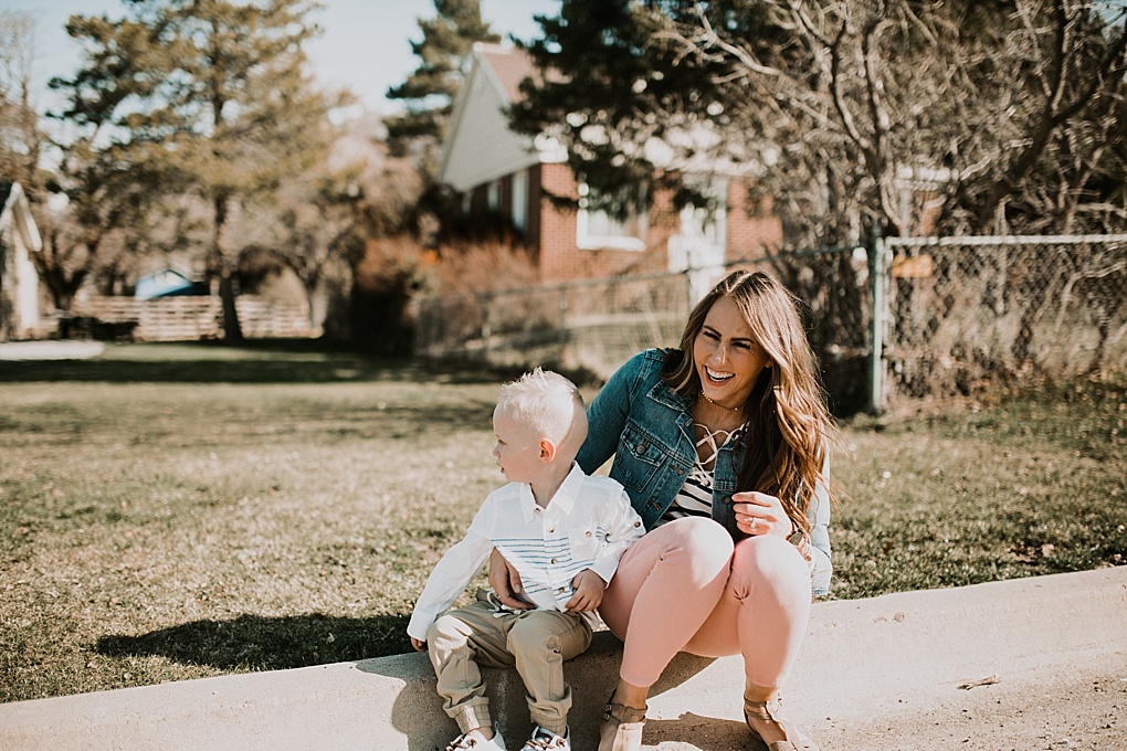 mom in blush pants with nautical stripe old navy top and jean jacket walking in the road with little boy in khaki joggers and white button up with blue stripes