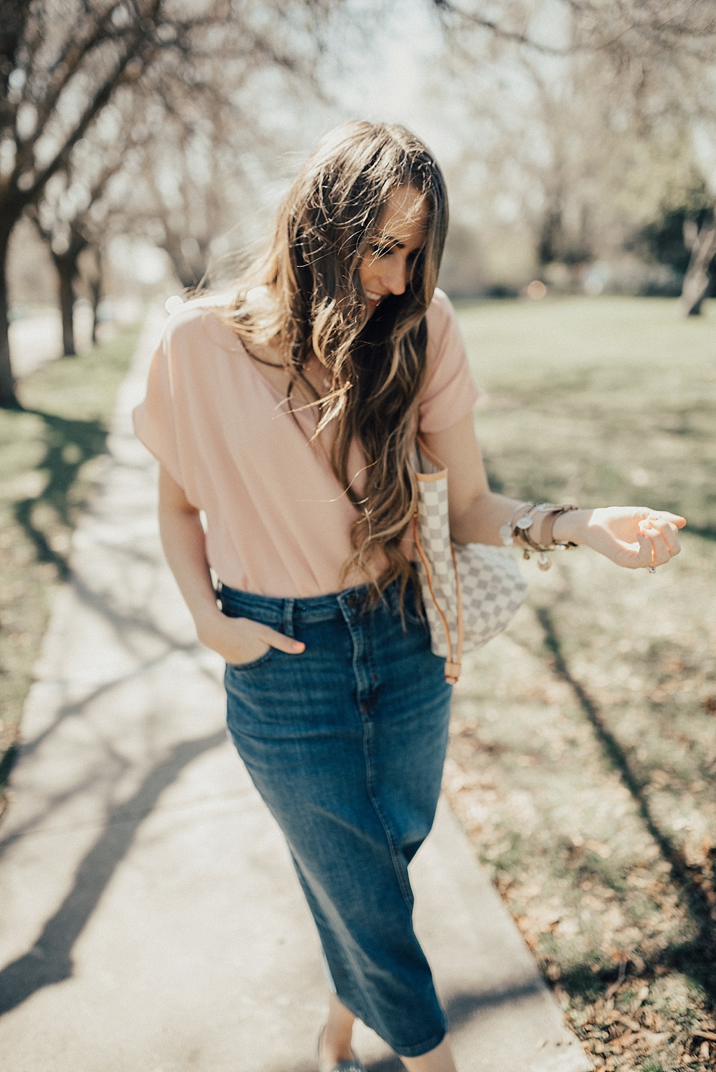 how to dress up and dress down a chiffon top with a denim skirt and jeans with long loosely curled brown hair and studded booties on
