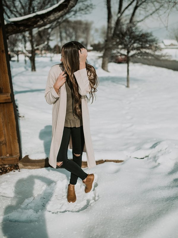 cream duster cardigan with olive peplum top black jeans and nike boots with long loose brown hair with caramel highlights curled